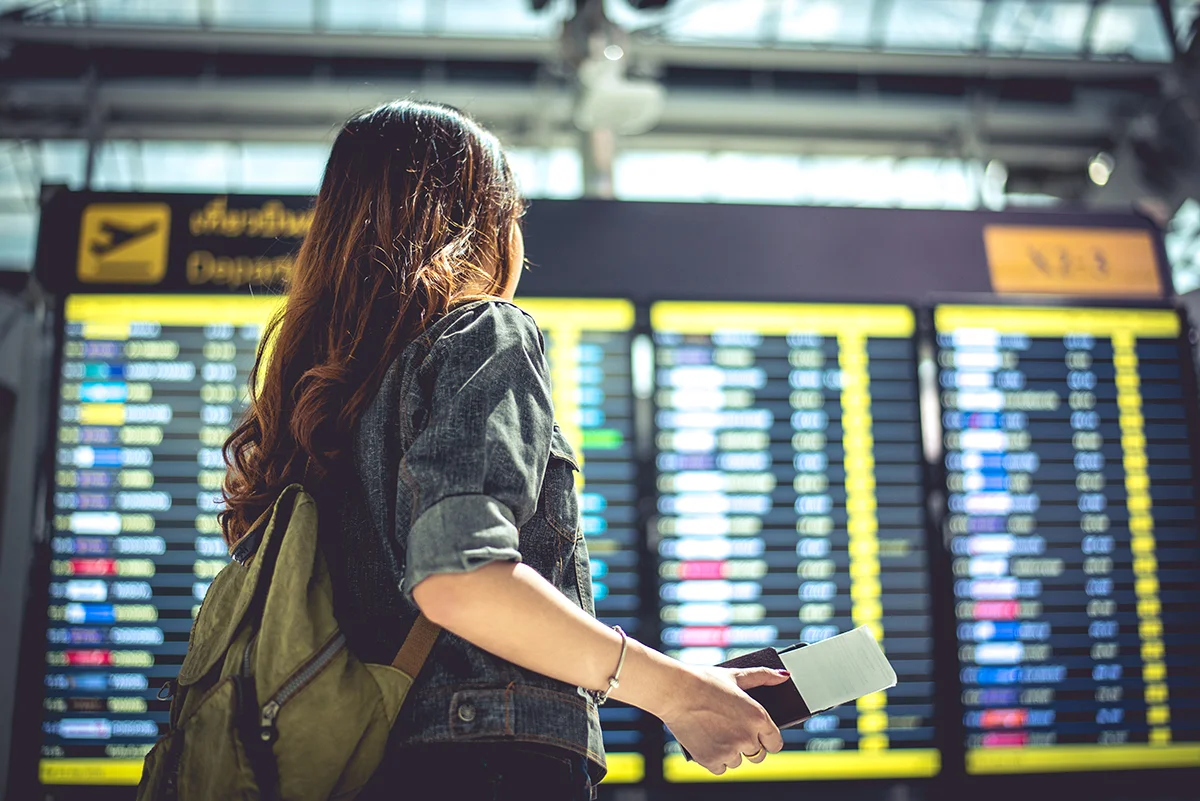 Beauty female tourist looking at flight schedules for checking t