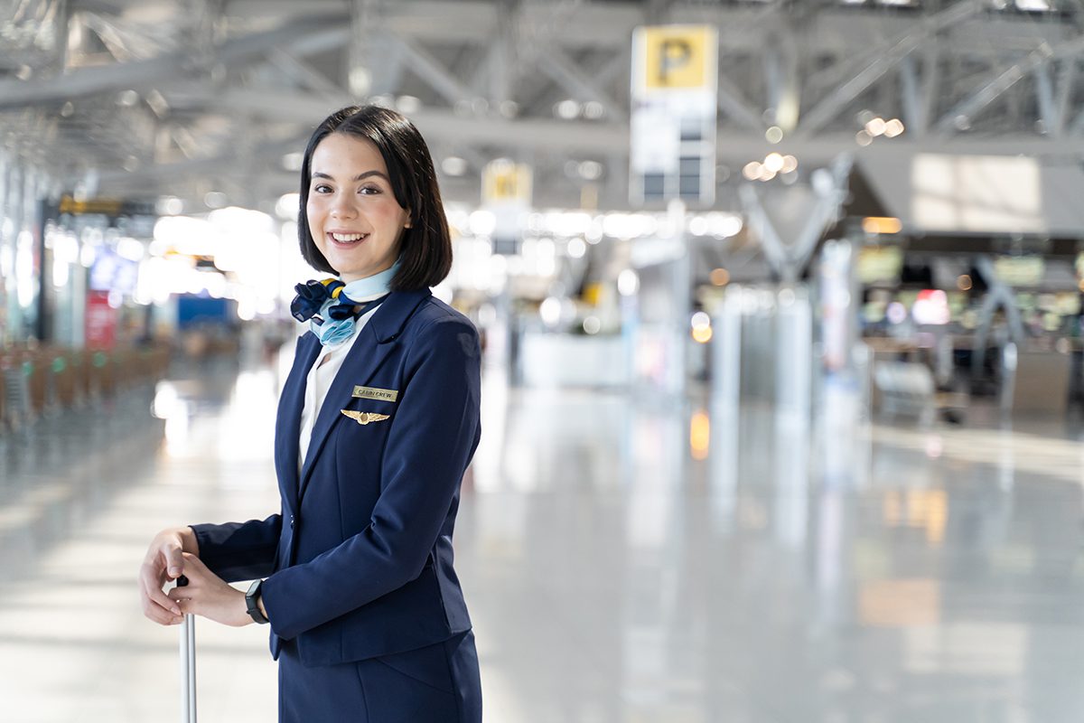 Portrait of Caucasian flight attendant standing in airport termi